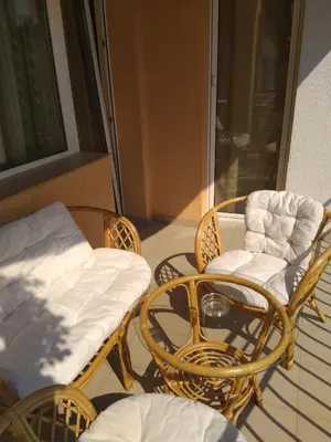 a porch with wicker chairs and a couch and a table at Laura in Primorsko
