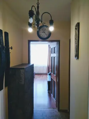 a room with a clock on the wall and a hallway at Laura in Primorsko