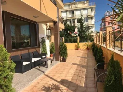 a patio of a building with benches and plants at Golden Sun in Pomorie