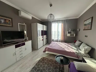 a bedroom with a bed and a flat screen tv at Golden Sun in Pomorie