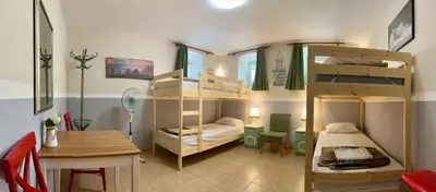 a dorm room with bunk beds and a table and a desk at Nomado Hostel in Varna City