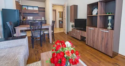 a living room with a table with a vase of flowers at DIAMOND APARTMENT №1 - RELAX HOLIDAY VIEWS SEA AND POOL in Burgas City