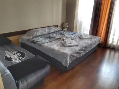 a bedroom with a bed and a couch with shoes on it at DIAMOND APARTMENT №1 - RELAX HOLIDAY VIEWS SEA AND POOL in Burgas City