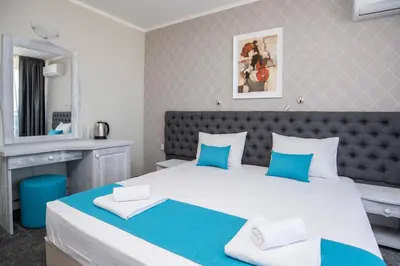 a bedroom with a large bed with blue and white pillows at Oasis Del Sol - Front Beach in Lozenets