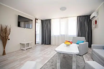 a living room with a couch and a table at Oasis Del Sol - Front Beach in Lozenets