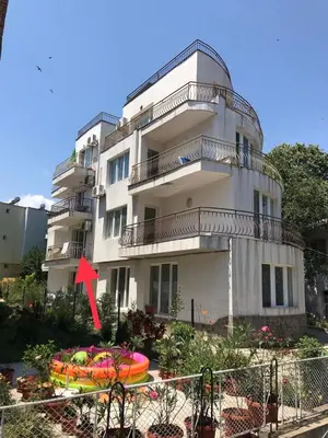 a building with a red arrow in front of it at Alice Apartment in Obzor
