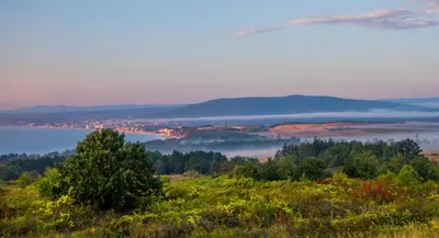 a view of a foggy valley with trees and a lake at Апартаменти Сънбрийз - Sunbreeze Apartments in Byala