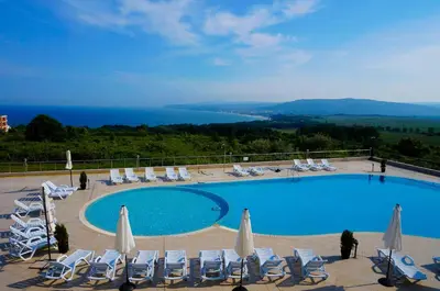 a swimming pool with lounge chairs and umbrellas and a view at Апартаменти Сънбрийз - Sunbreeze Apartments in Byala