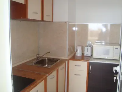 a small kitchen with a sink and a microwave at Hotel Astra in Ravda