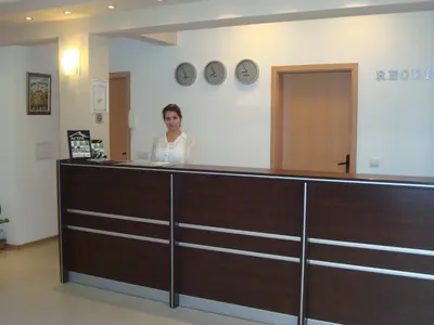 a woman standing behind a counter in a room at Hotel Astra in Ravda