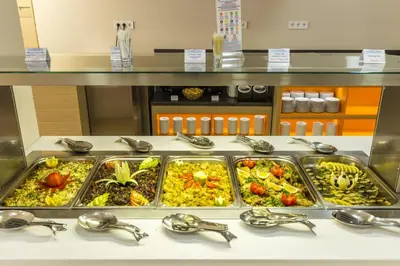 a buffet line with many trays of food at Kuban Resort & Aquapark - All Inclusive in Sunny Beach