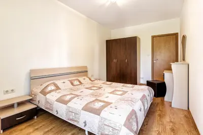 a bedroom with a large bed and wooden floors at Kuban Resort & Aquapark - All Inclusive in Sunny Beach