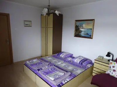 a bedroom with a bed with a purple comforter at Дом Христови in Chernomorets