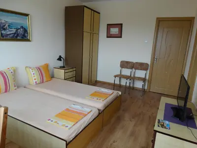 a bedroom with a bed and a table and a door at Дом Христови in Chernomorets