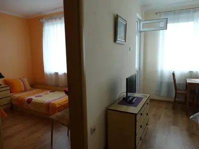 a bedroom with a bed and a table with a television at Дом Христови in Chernomorets