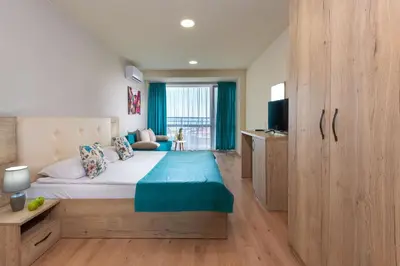 a bedroom with a large bed and a television at Sea View Hills in Sveti Vlas