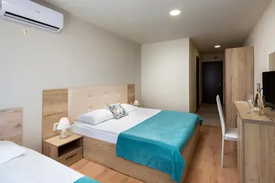 a bedroom with a bed and a desk with a television at Sea View Hills in Sveti Vlas
