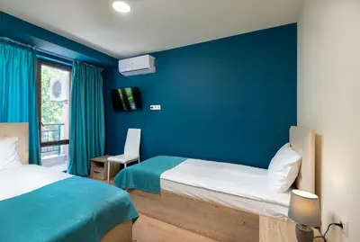 a bedroom with two beds and a blue wall at Sea View Hills in Sveti Vlas