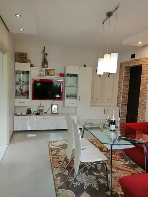 a living room with a glass table and a tv at Apartament Peyo Yavorov in Burgas City