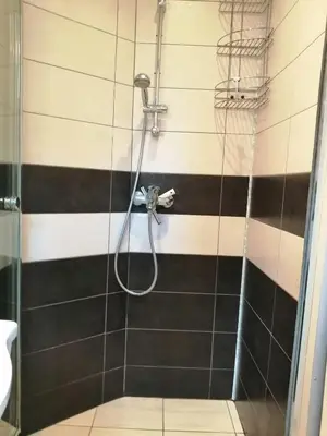 a shower in a bathroom with black and white stripes at Apartament Peyo Yavorov in Burgas City
