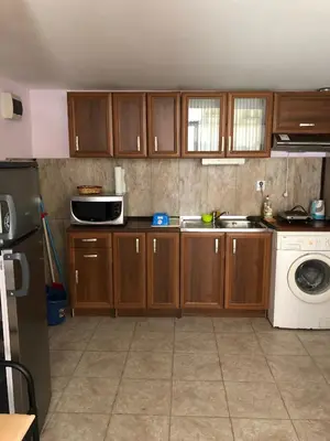 a kitchen with wooden cabinets and a washing machine at Dunav Str. in Ravda