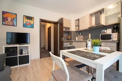 a kitchen and dining room with a white table and chairs at Vera by RV Apartments in Varna City
