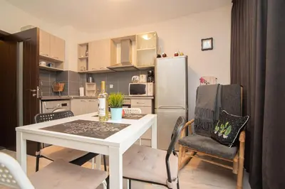 a kitchen with a white table and chairs and a refrigerator at Vera by RV Apartments in Varna City