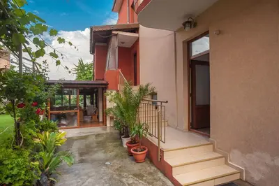 a house with stairs and potted plants on it at Guest House Galema in Obzor