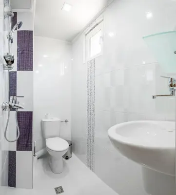 a white bathroom with a toilet and a sink at Guest House Galema in Obzor