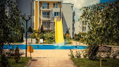 a pool with a water slide in front of a building at Apartment in Nessebar Fort Club in Sunny Beach