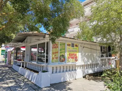 a white building with signs on the side of it at Familia Fantastiko in Kiten