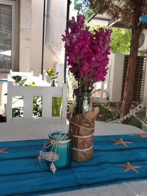a vase with purple flowers sitting on a table at Familia Fantastiko in Kiten