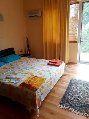 a bedroom with a bed and a window and a rug at Apartment Zora in Sozopol