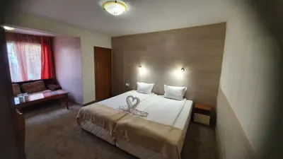 a hotel room with a bed with a swan on it at Family Hotel Kedara in Burgas City