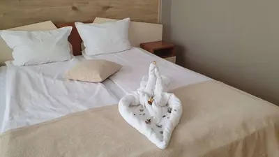 a bed with white towels on top of it at Family Hotel Kedara in Burgas City