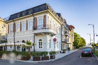 a building on a street with a car parked in front at Villa Promenade in Burgas City