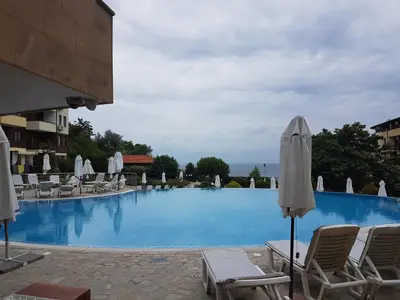 a large swimming pool with chairs and umbrellas at Apartment Garden of Eden in Sveti Vlas