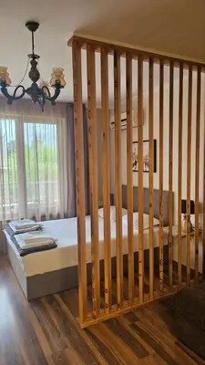 a wooden bed in a room with a crib at Apartment 7 and Studio 2 Quietly and peaceful place to relax in Sozopol