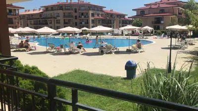 a pool with people in chairs and umbrellas at Star Dreams, Sveti Vlas in Sveti Vlas