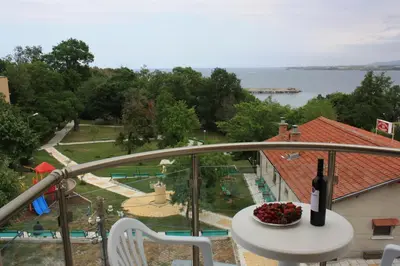 a bottle of wine sitting on a table on a balcony at Style Place in Kiten