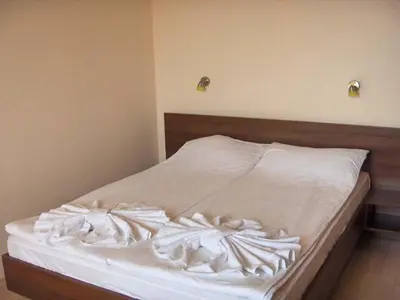 an unmade bed with white sheets in a bedroom at Style Place in Kiten
