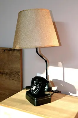 a black telephone sitting on a desk with a lamp at Boutique Villa Amalia in Chernomorets