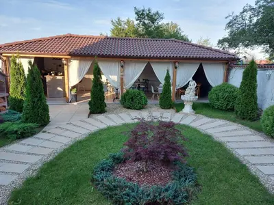 a house with a garden with a statue in the yard at Boutique Villa Amalia in Chernomorets