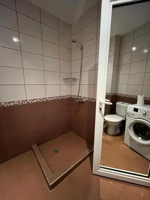 a bathroom with a toilet and a washing machine at Mario Beach Apartment Nessebar in Nesebar