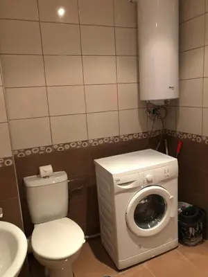 a bathroom with a toilet and a washing machine at Mario Beach Apartment Nessebar in Nesebar