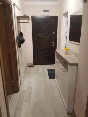 a hallway with a kitchen with a black door at Apartment EliMar in Burgas City
