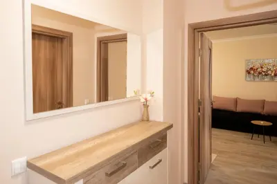 a bathroom with a large mirror on the wall at Apartment EliMar in Burgas City