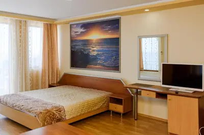 a bedroom with a bed and a desk with a television at Guest House Ianis Paradise in Nesebar