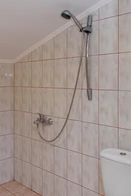 a shower head in a bathroom with a toilet at Guest House Ianis Paradise in Nesebar