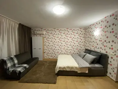 a bedroom with a bed and a couch at Квартира у моря in Pomorie